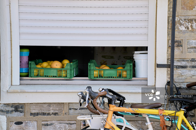 商店外停放着自行车，装满橘子的篮子的特写镜头图片素材
