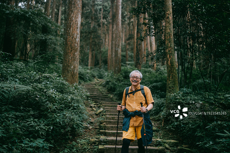 快乐的老年男人在森林里徒步旅行图片素材