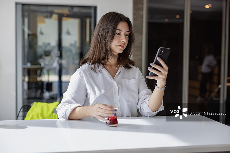 手拿一杯土耳其茶准备饮用的商务女人图片素材