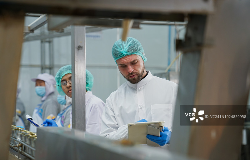 团队在工厂进行质量检验，并合作出口食品生产线。图片素材