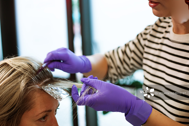 专业染发师在美容院内使用锡纸进行染发图片素材