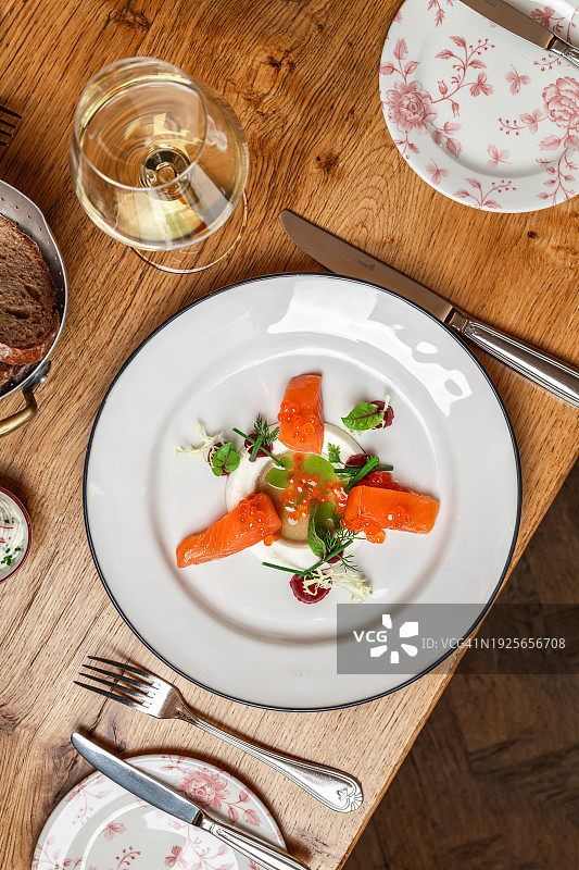米其林星级餐厅的精致三文鱼开胃菜，配以烟熏三文鱼、三文鱼鱼子酱、油醋汁和萝卜奶油图片素材