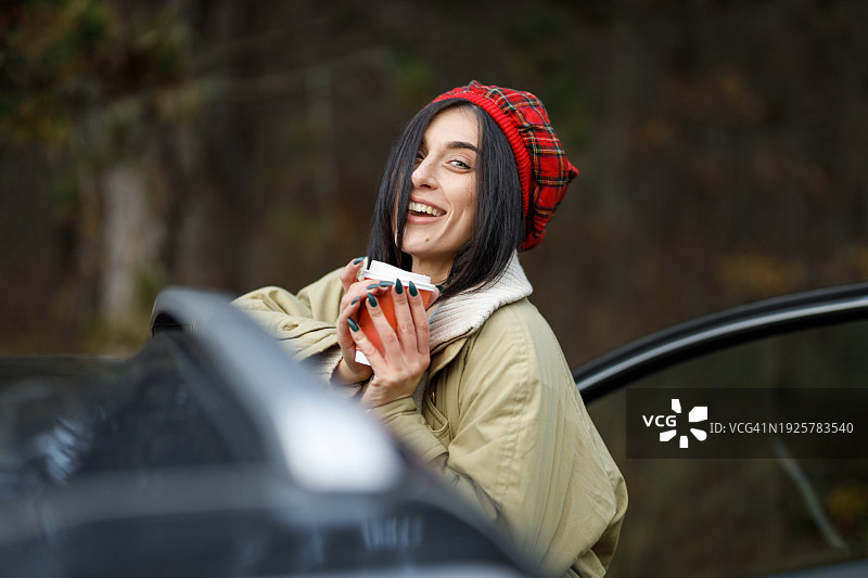 女子喝着咖啡享受冬季公路旅行图片素材