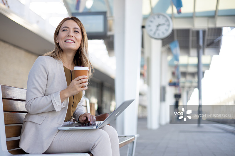 在铁路站台上使用笔记本电脑的上班族图片素材