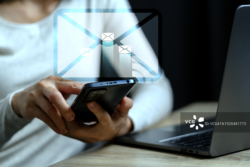 商务女人通过笔记本电脑和智能手机向客户发送电子邮件图片素材