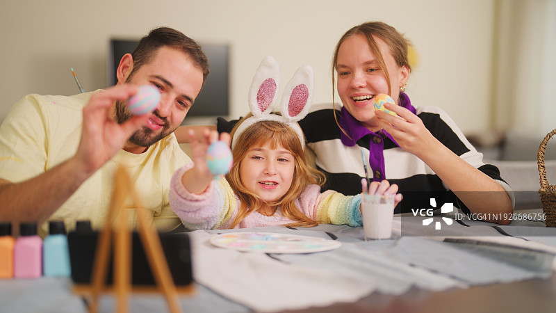 年轻家庭在客厅用手机与亲友视频图片素材