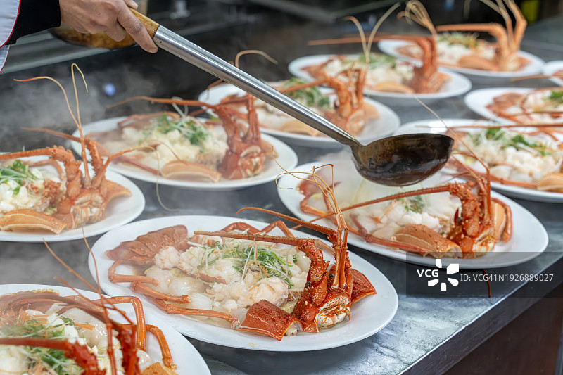 厨师在盘中处理熟龙虾图片素材