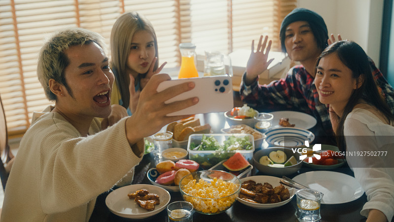 亚洲年轻人在家用餐时用手机自拍图片素材