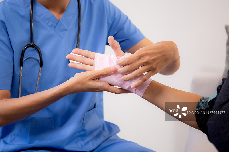 医护人员在家为手部受伤老年妇女包扎图片素材