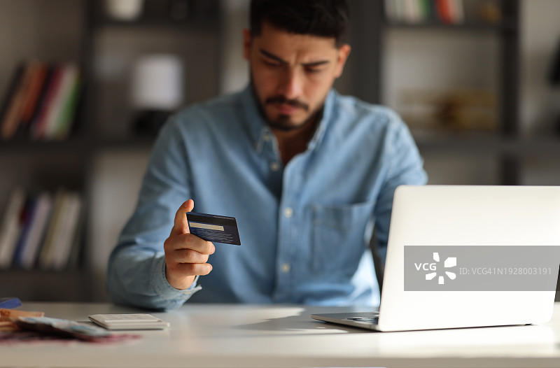 男人，手和带有信用卡的手提电脑，用于在桌子上进行网上购物、电子商务或无线交易。男性在电脑上的手用于网上银行、应用程序或在桌子上进行金融购买或支付图片素材