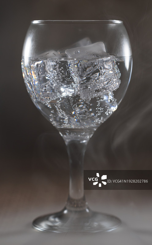 灰色背景下玻璃杯中冰块的特写图片素材