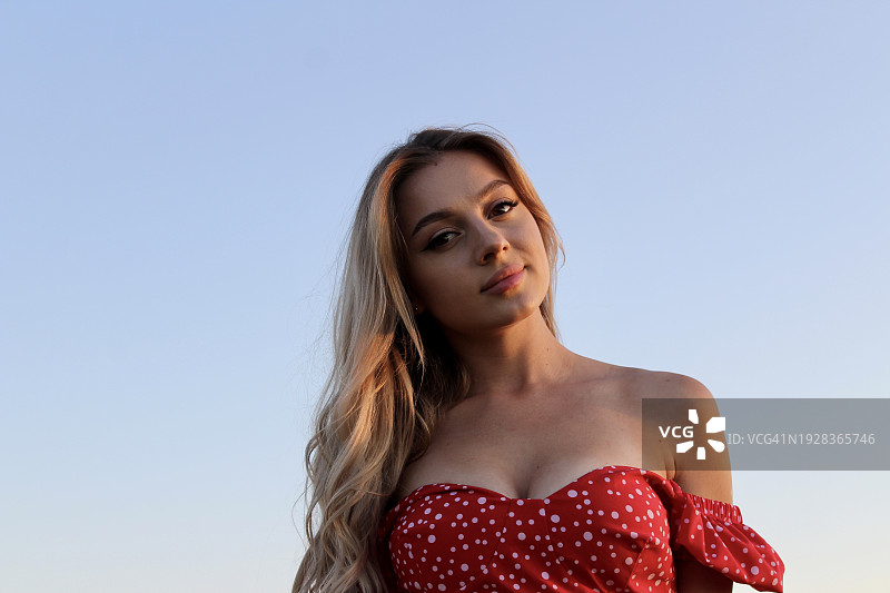 在晴朗天空下美丽的年轻女性肖像图片素材