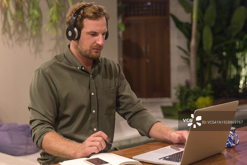 数字游民在夜晚的别墅工作图片素材