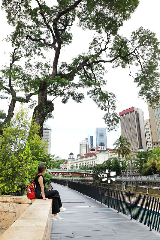 在吉隆坡城市景观中独自旅行的可爱亚洲女子图片素材