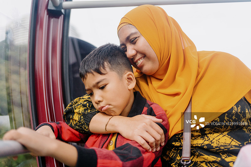 母亲抱着她沮丧的儿子图片素材