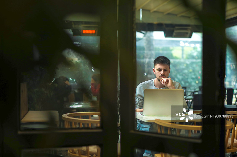 在咖啡馆用笔记本电脑工作的自由职业者图片素材