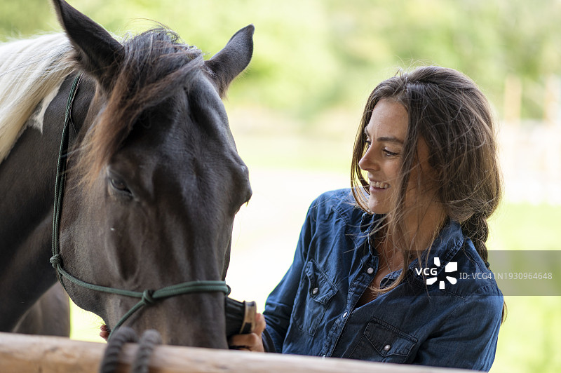 年轻女人抚摸马的口鼻图片素材