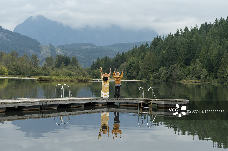 站在湖边码头上的土著妇女图片素材
