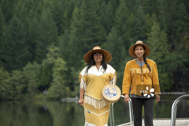 站在湖边码头上的土著妇女图片素材