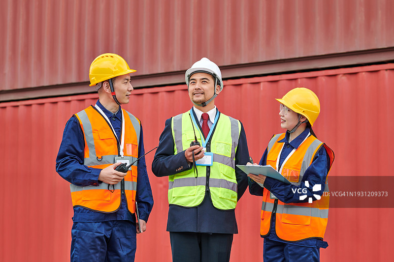 三位亚洲同事在装卸区讨论工作图片素材