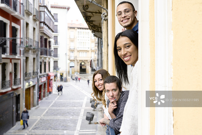 靠在公寓阳台窗户上看向镜头的人群侧视图图片素材