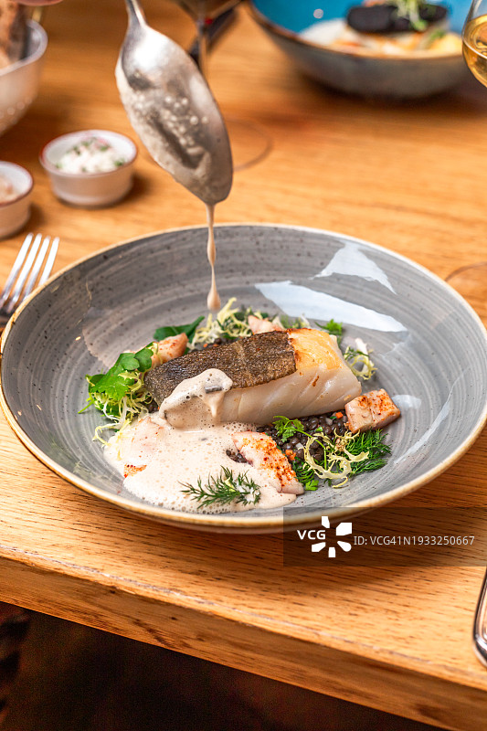 米其林星级餐厅供应的扁豆、泡沫酱汁肉汁佐餐白鱼片图片素材