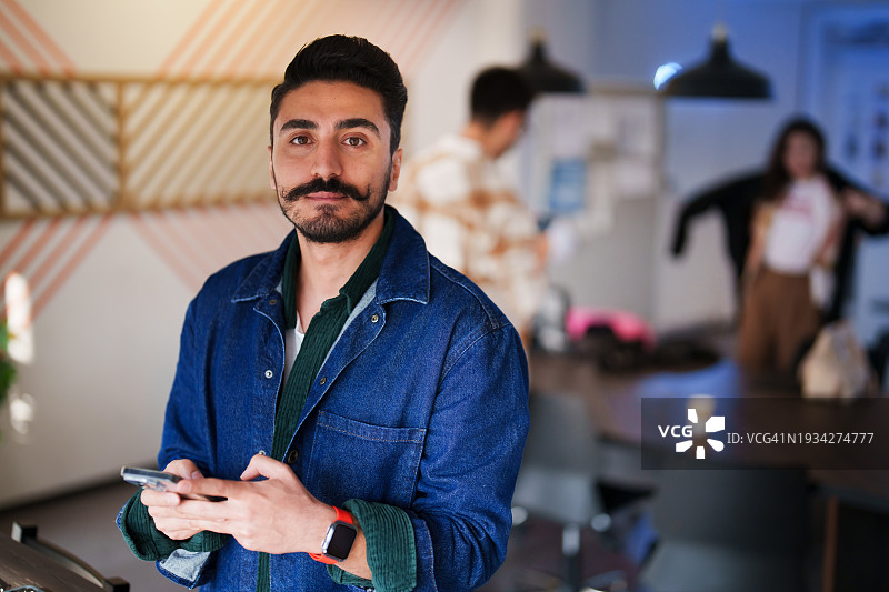 男子在他的办公室使用智能手机图片素材
