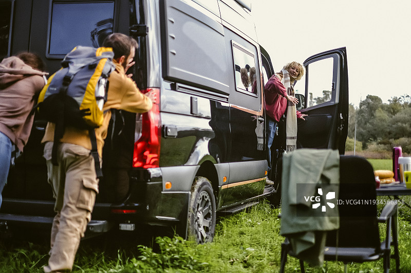 朋友们开着厢型车露营玩乐图片素材