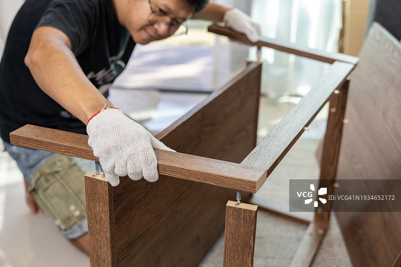 男子在新家组装自组装家具图片素材