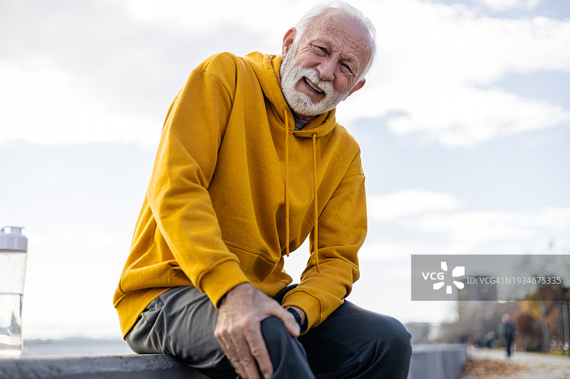 活力老年男性在户外锻炼时感到膝盖疼痛图片素材