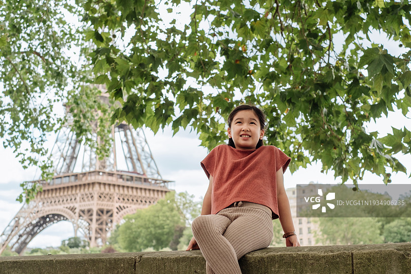 可爱亚洲小女孩在埃菲尔铁塔前享受阳光图片素材