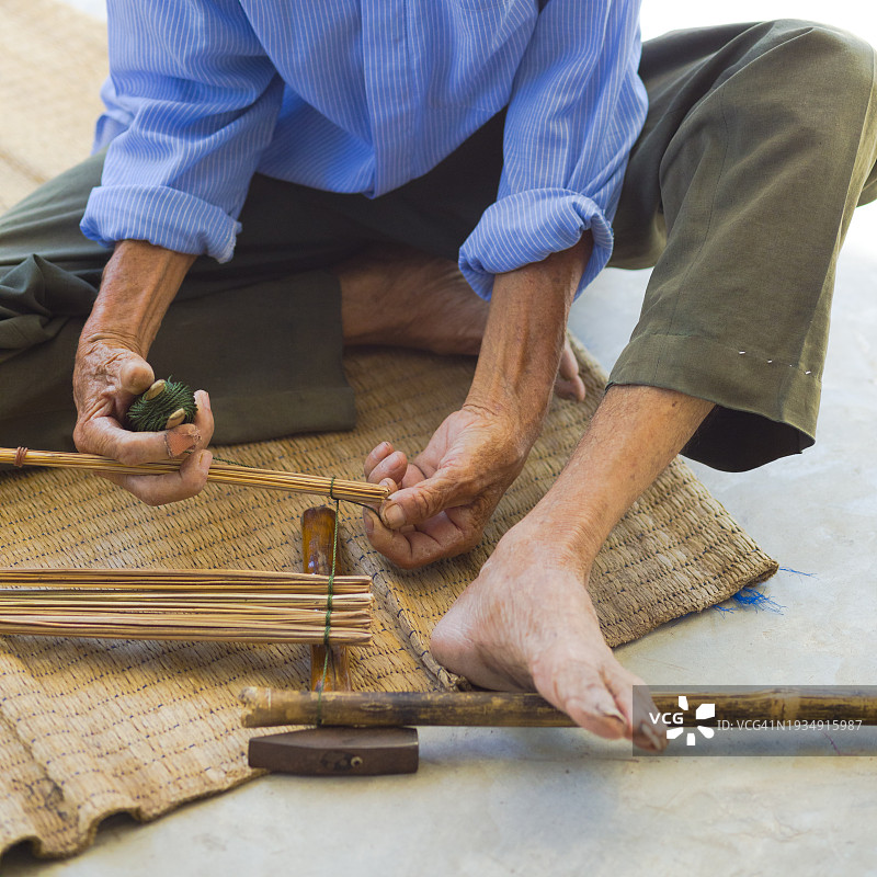 坐在地上的泰国老人正在用竹子做手工图片素材