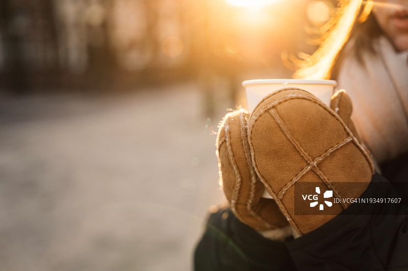 戴手套的手拿着外卖热饮杯的特写图片素材