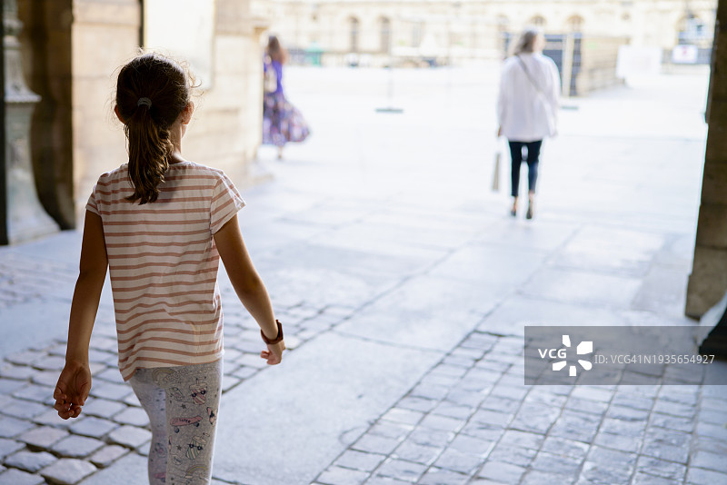 在城市户外穿着舒适服装的年轻女孩的背影图片素材