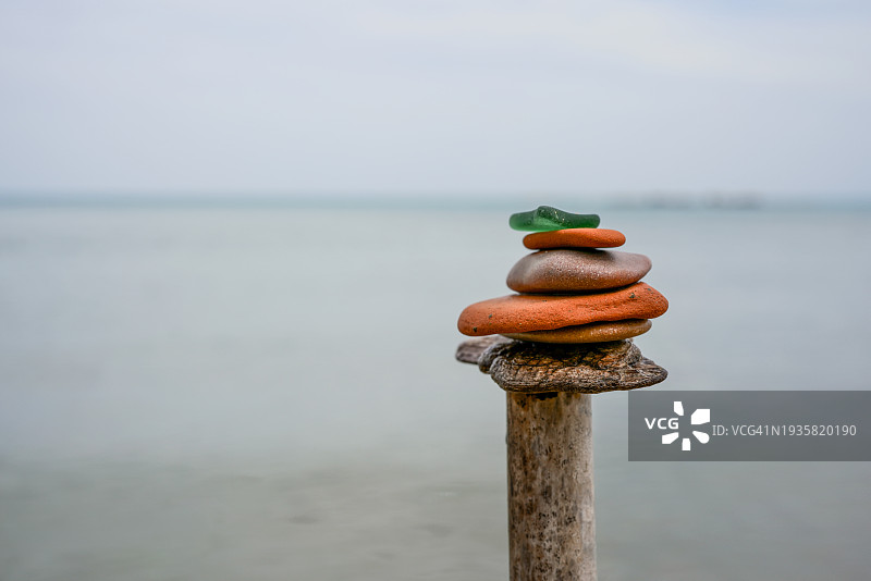 海边木桩上的彩色鹅卵石堆叠——放松冥想平衡模型图片素材