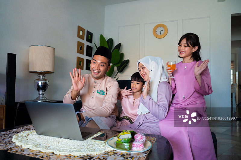 马来西亚穆斯林家庭在开斋节庆祝活动期间通过笔记本电脑向亲友发送视频祝福图片素材