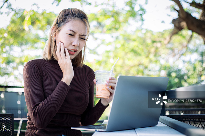 牙痛概念：年轻自由职业女性遭受牙痛、蛀牙或敏感图片素材
