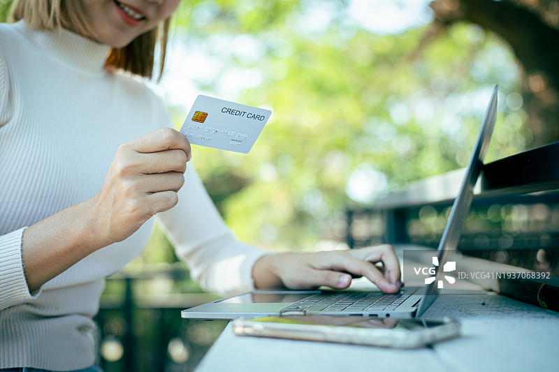 特写：使用笔记本电脑和信用卡在线购物/支付图片素材
