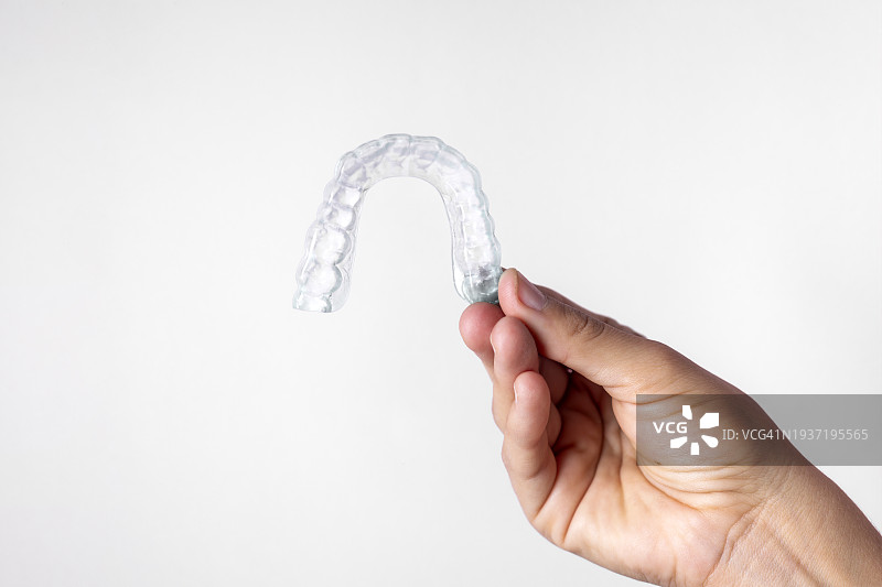 女人手持隐形牙齿矫正器图片素材