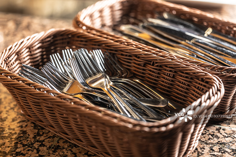 餐馆餐桌上篮子里的刀叉餐具图片素材