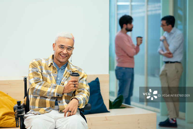 在现代共享办公空间微笑的拉丁美洲残疾青年男子肖像图片素材