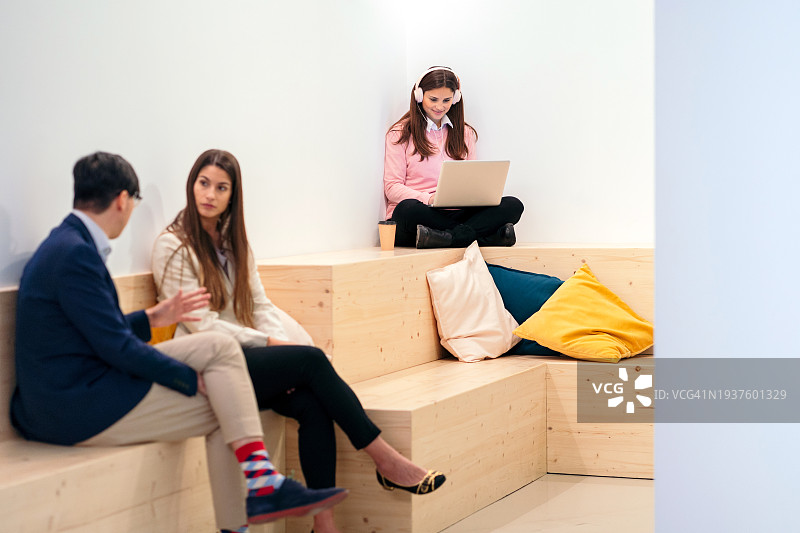 在现代彩色共享办公休息区喝咖啡的多元化人群图片素材