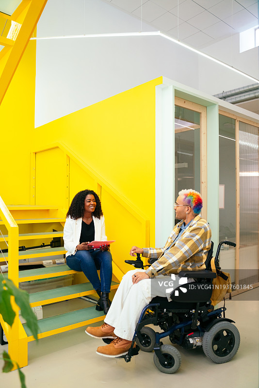 竖版：非洲女商人和坐在轮椅上的年轻员工图片素材