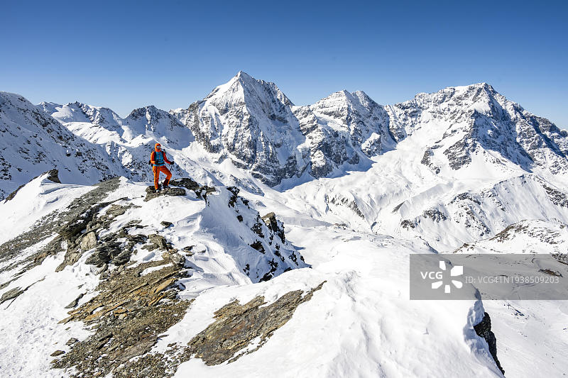 登山者站在雪山前的壁架上，马德里奇峰顶，奥特勒阿尔卑斯山，意大利，欧洲图片素材