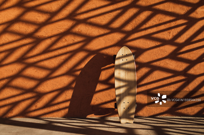 橙色墙壁背景上的木制长板与光影图片素材