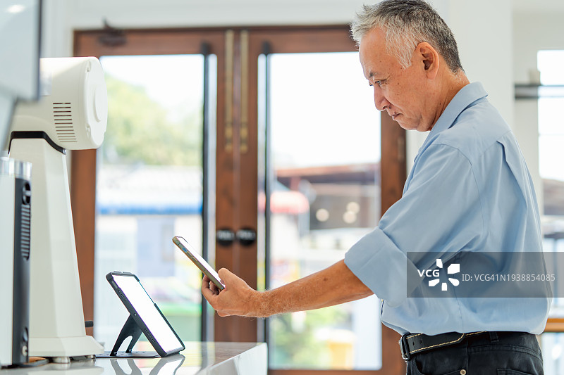 顾客在咖啡馆扫描二维码，使用智能手机进行便捷的非接触式支付图片素材