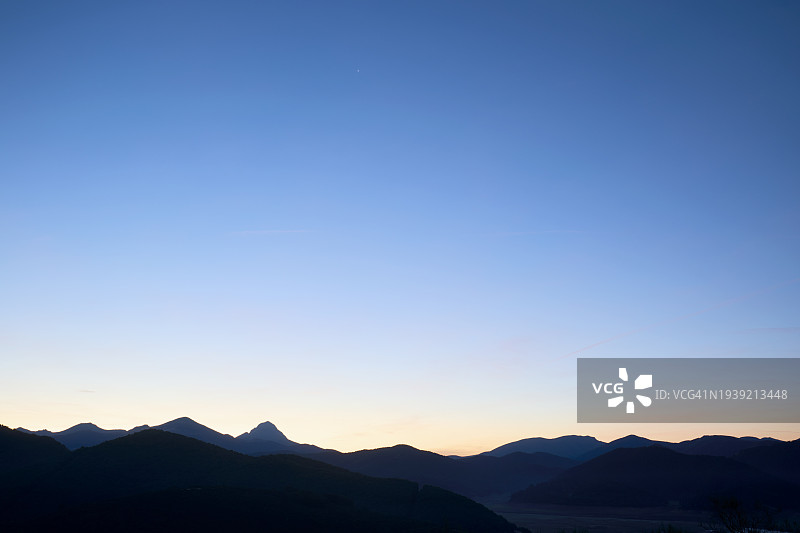 田园诗般的日出时分，晴空下的山脉剪影图片素材