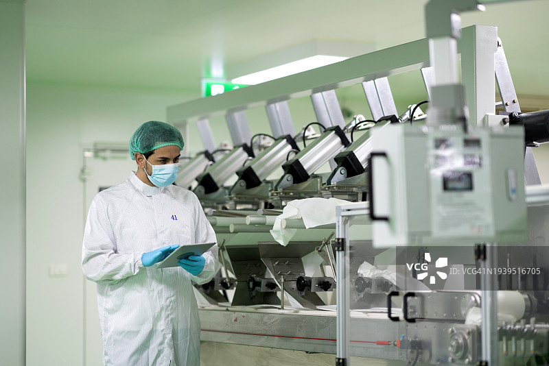 实验室技术员在无菌室检查自动化制药机器图片素材
