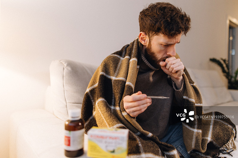 男子感冒发烧量体温咳嗽图片素材