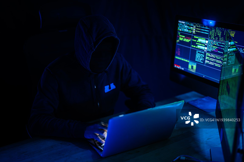 夜间绿色灯光下黑客操作电脑图片素材